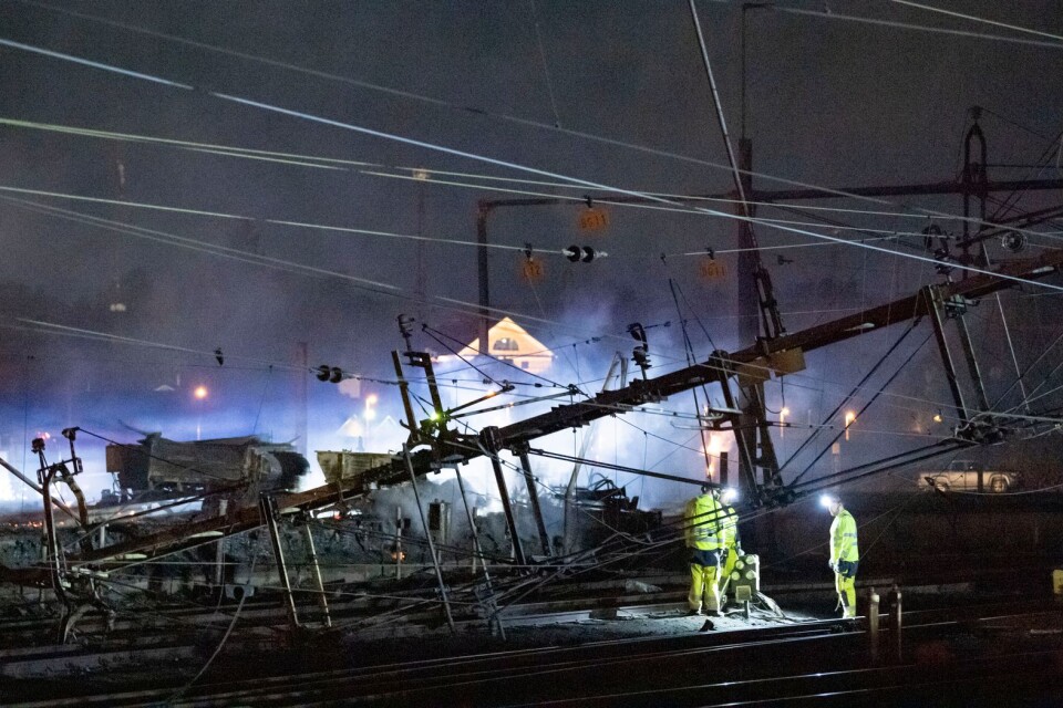 Under natten till torsdagen pågick arbete vid de kontaktledningar som fallit ner över spåren norr om stationen i Hässleholm i samband med en våldsam brand i en industribyggnad.
