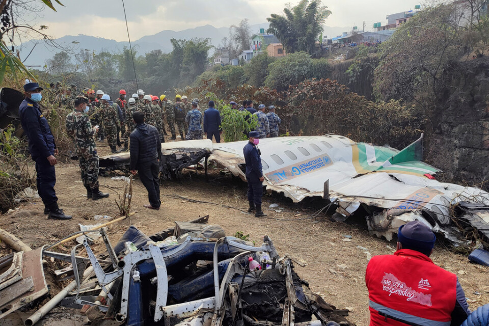 Räddningsarbetare vid vraket av det förolyckade flygplanet i Pokhara på måndagen.