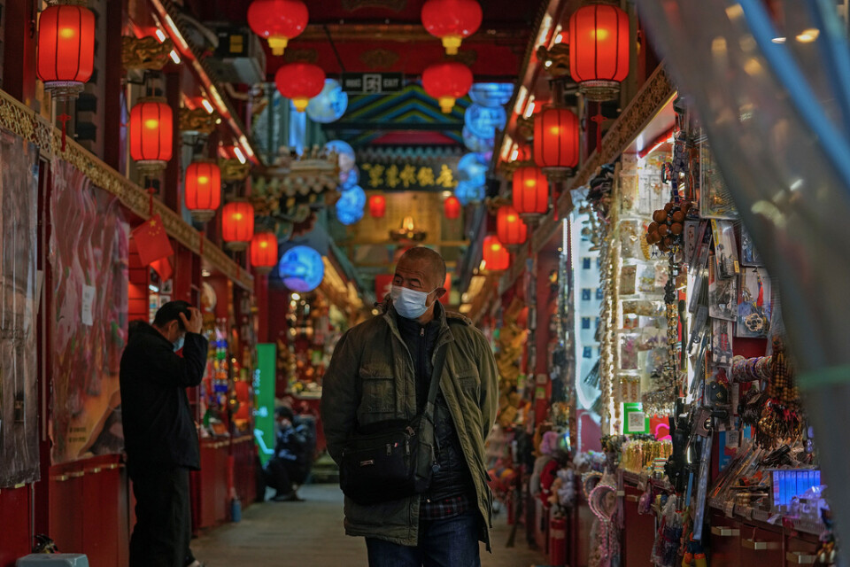 En man med munskydd passerar en av Pekings många marknader. Arkivbild.