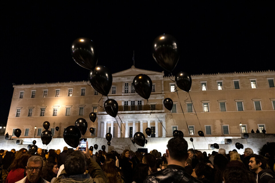 Protesterande med svarta ballonger under en tyst demonstration utanför parlamentet i Aten.
