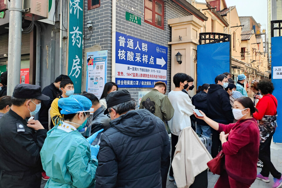 Människor står i kö utanför ett sjukhus i Shanghai för att testa sig för coronaviruset.