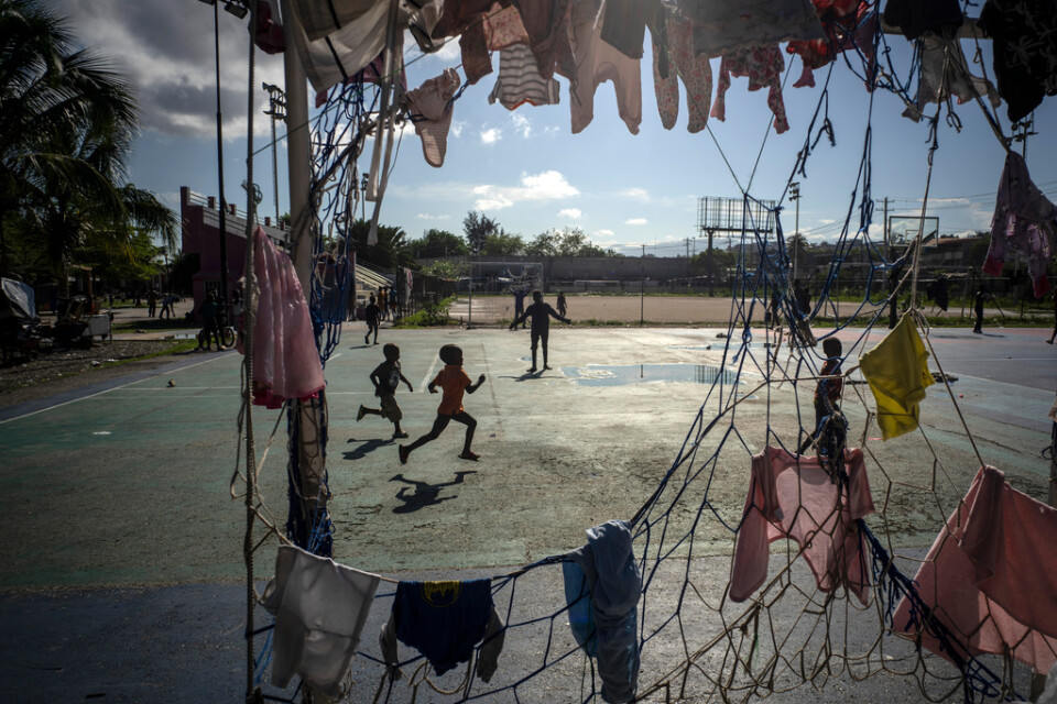 Barn springer på en fotbollsplan i Port-au-Prince där målet används som tvättställning. Bild från oktober 2022.