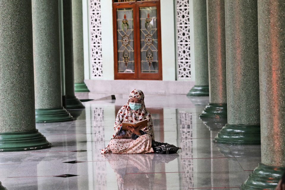 Koranläsning med munskydd i väntan på att bryta fastan under ramadans första dag i Jakarta på tisdagen.