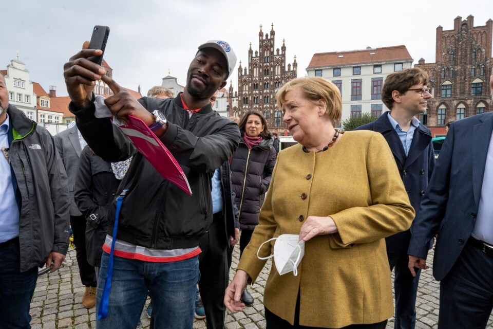 Angela Merkel poserar med en besökare på marknaden i hennes tidigare valkrets Marlow i nordöstra Tyskland.