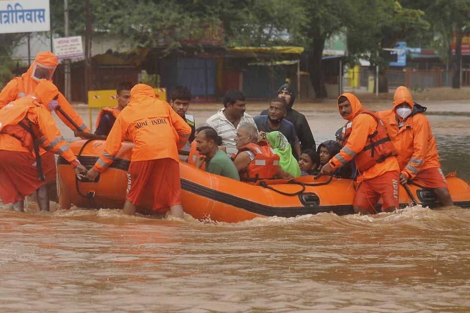 Räddningspersonal evakuerar människor som strandsatts i översvämningar i Kolhapur i västra Indien, efter kraftiga monsunregn.