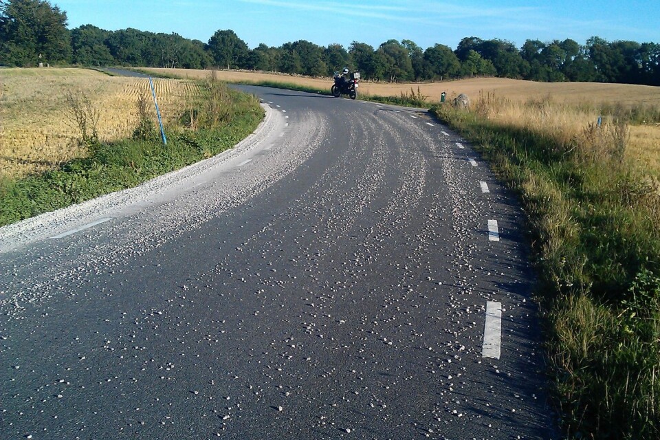 En kurvig väg i nordöstra Skåne som har lagats men där gruset inte sopats undan efter en stödremselagning.