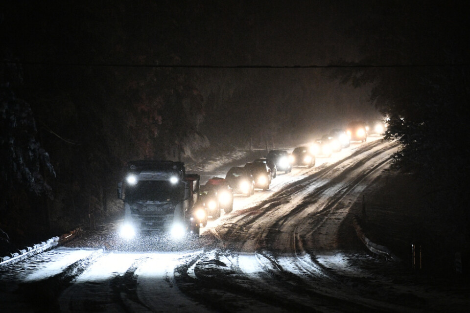 Bilar på kö efter en lastbil som står still på riksväg 21 på grund av snöfallet på onsdagseftermiddagen och kvällen.