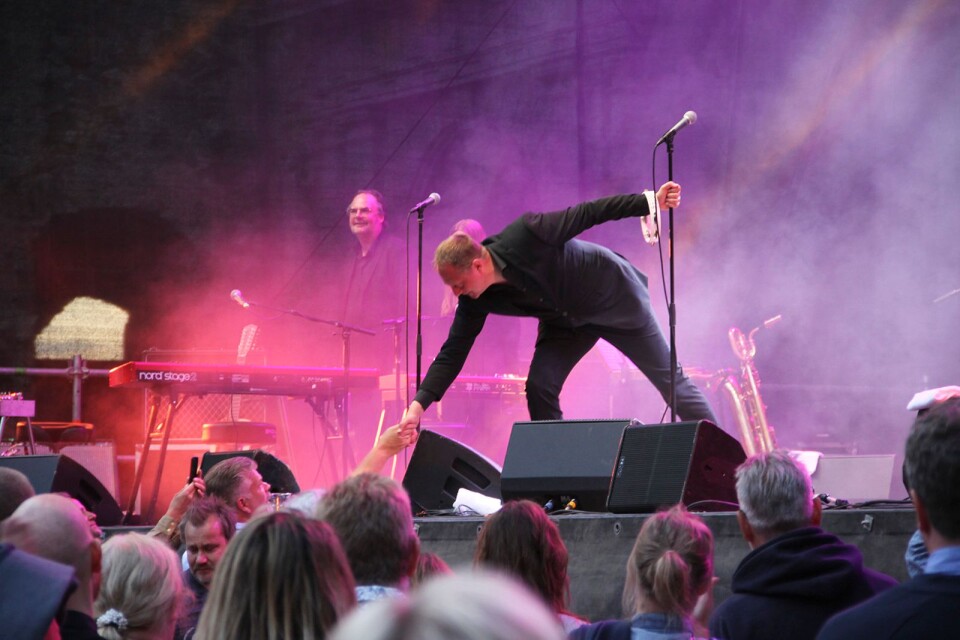 Publiken tackar bandet för spelningen. Sångaren Magnus Carlson tar i hand med flera personer i publiken.