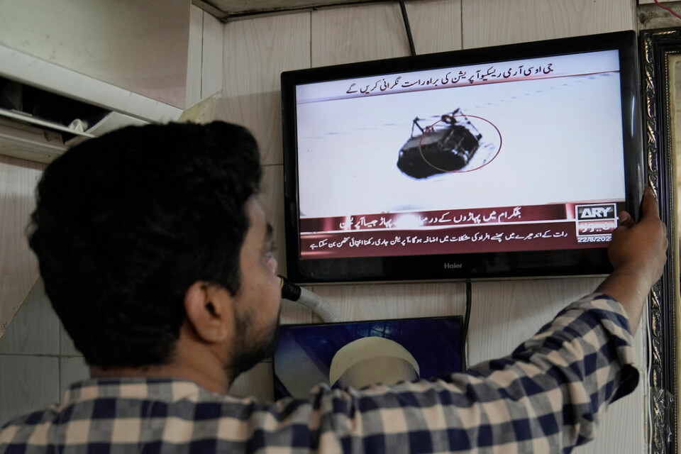 En man i Lahore i Pakistan tittar på räddningsarbetet som direktsändes i tv.