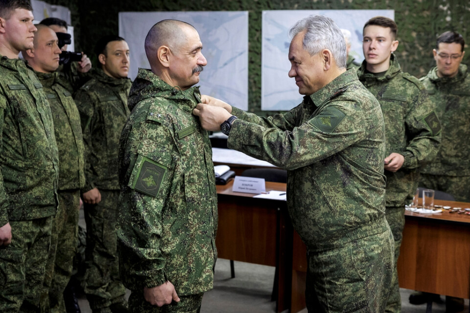 Rysslands försvarsminister Sergej Sjojgu, till höger främst i bild, sätter en medalj på en officerare i en anläggning någonstans i Ukraina. Bilden har distribuerats av det ryska försvarsdepartementet.