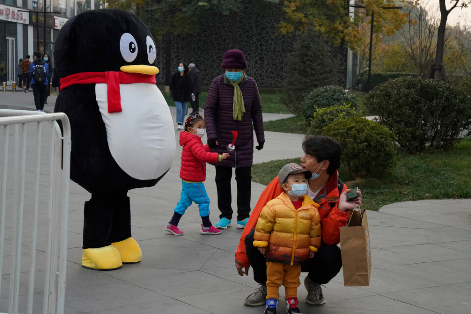 Den kinesiska nätjätten Tencents maskot tillsammans med kinesiska barn i Peking. Arkivbild.