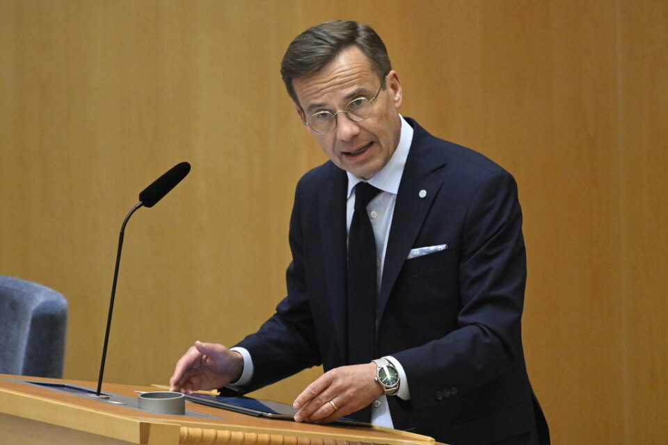 Statsminister Ulf Kristersson (M) i talarstolen under partiledardebatten i riksdagen.