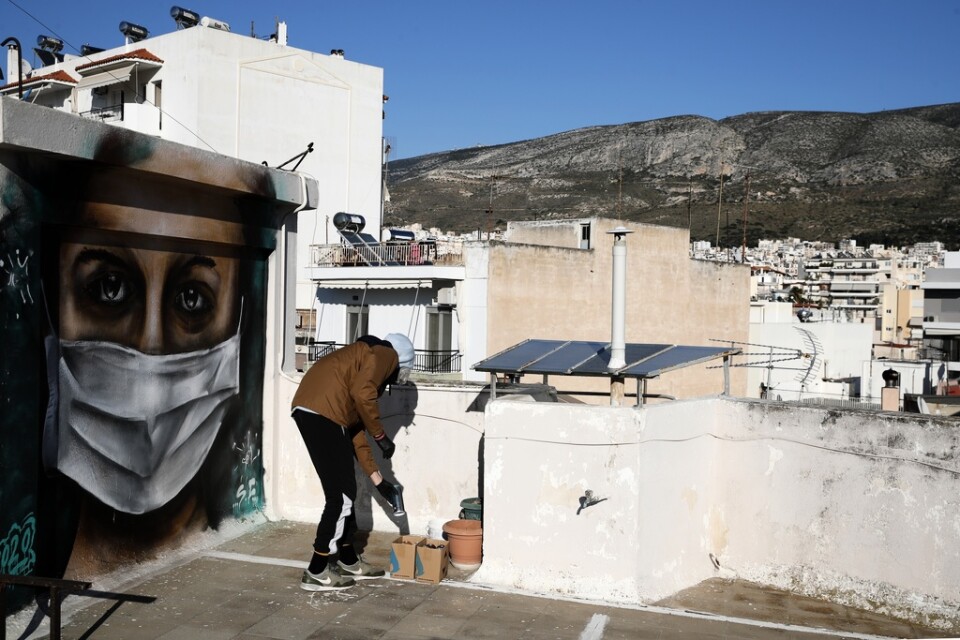 En grekisk graffitikonstnär har målat en kvinna med munskydd i Aten. Arkivbild.