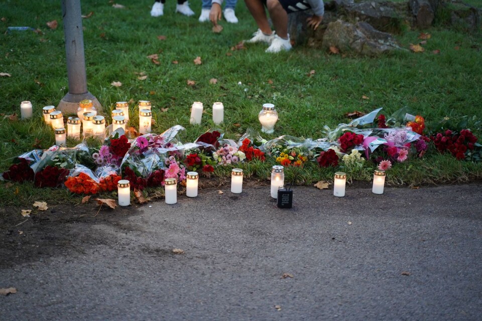 Tända ljus och blommor på Nydalavägen där en man i helgen blev ihjälskjuten.