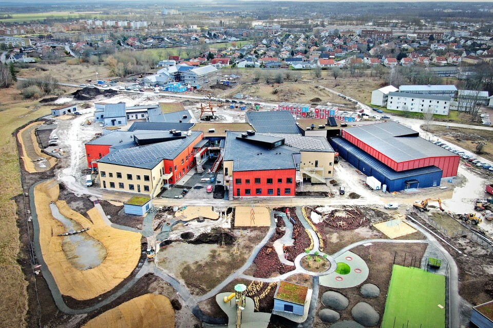 Baksidan av Lingenässkolan (sedd från Näsby fält). Till vänster två byggnader för grundskola, i gul och röd betong som liknar träpanel. Till höger syns idrottshallen.