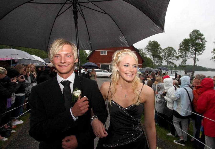 Markus Hjelm och Emma Grenvall på väg genom folk- och paraplyhavet.