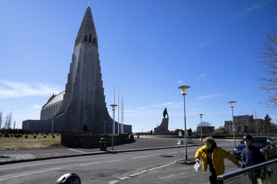Två pojkar passerar ett tomt torg framför Hallgrímskirkja i Reykjavik i slutet av april, då landet meddelade lättnader i coronarestriktionerna.