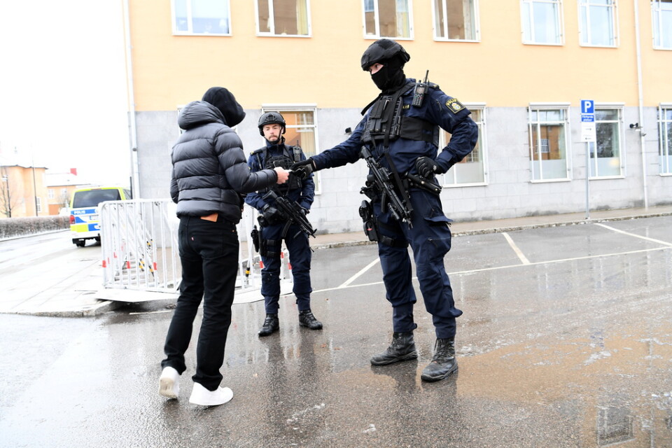 Beväpnade poliser kontrollerar besökare utanför tingsrätten i Linköping, där förhandlingen i dag inleds om tre mord i Norrköping.