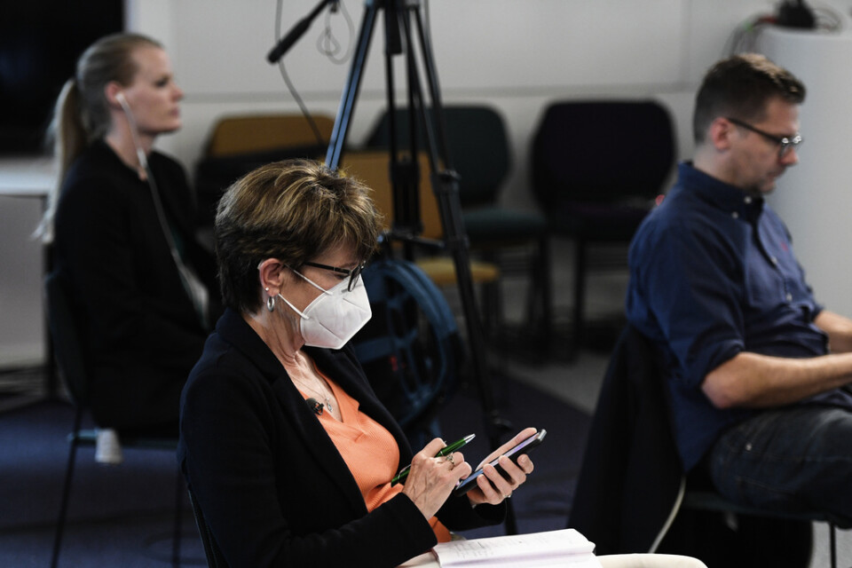 En reporter med munskydd under en av Folkhälsomyndighetens pressträffar om covid-19.
