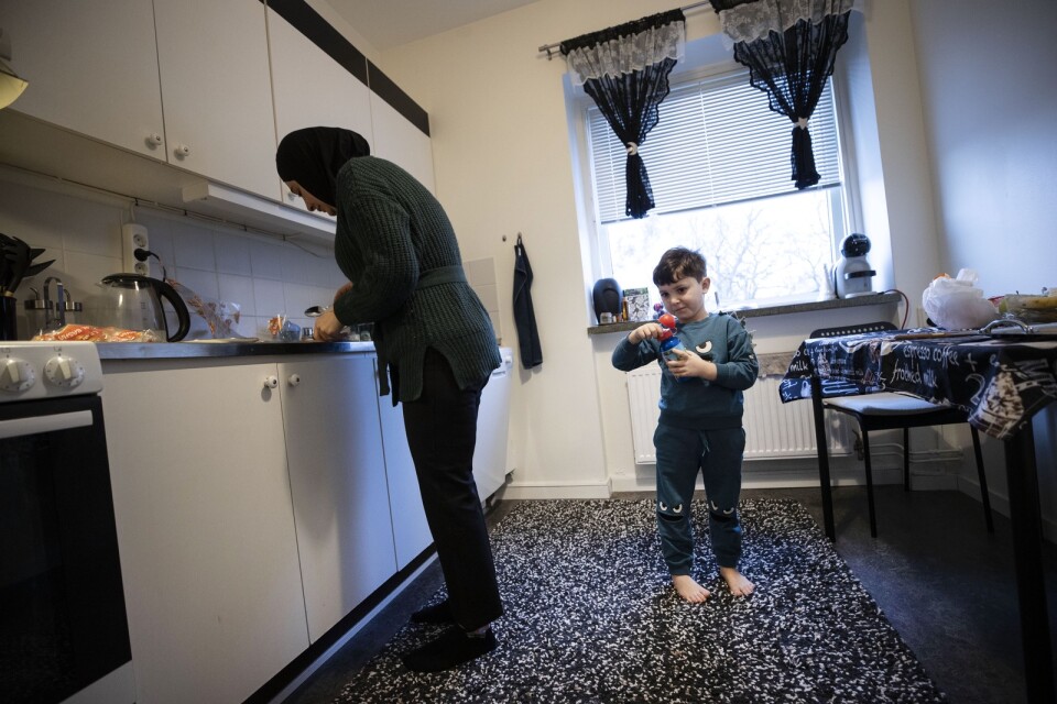 Lille Adam håller mamma Assma sällskap i köket.