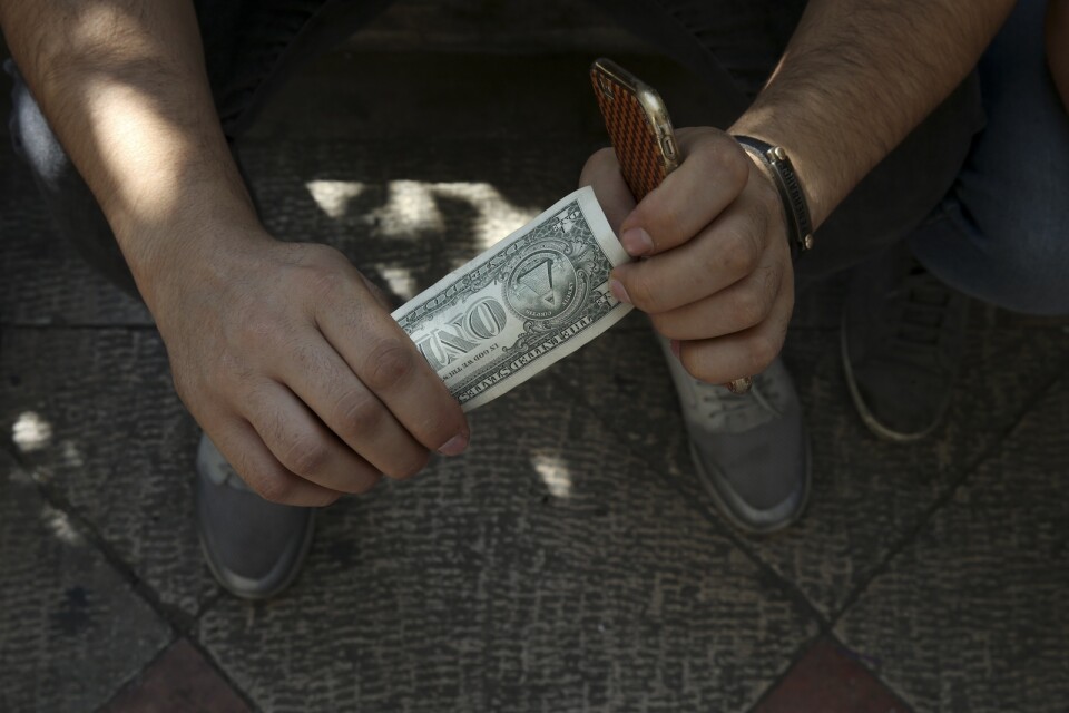 En svartväxlare på en gata i Irans huvudstad Teheran med dollar i handen. Arkivbild.