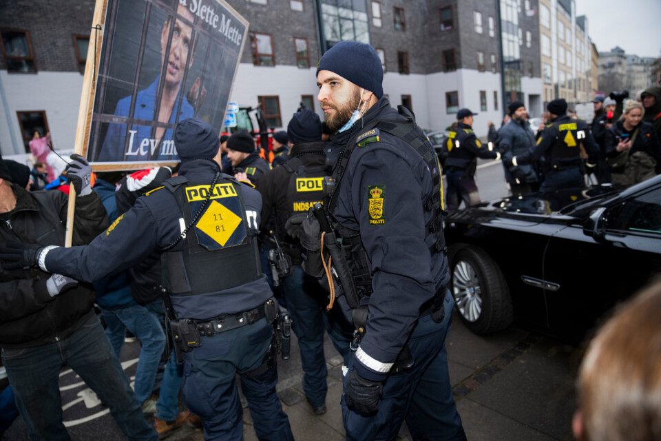 Poliser föser undan demonstranter utanför rättslokalen i Köpenhamn där statsminister Mette Frederiksen (S) förhördes av en kommission om beslutet att massavliva landets minkar.