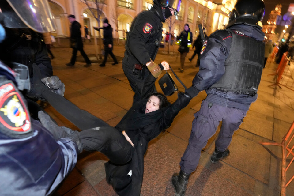 Rysk polis i S:t Petersburg griper en demonstrant som på onsdagen protesterar mot den ryska invasionen i Ukraina.