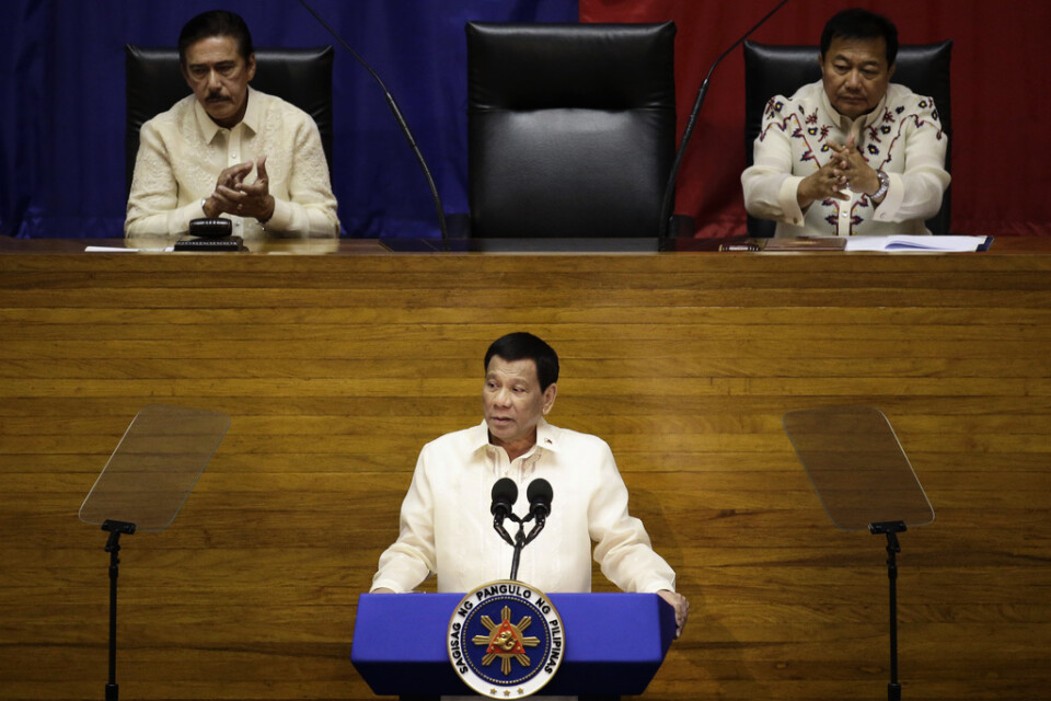 President Rodrigo Duterte i mitten talar och får applåder av Vicente Sotto till vänster och Pantaleon Alvarez, talman i representanthuset, till höger. Arkivbild.