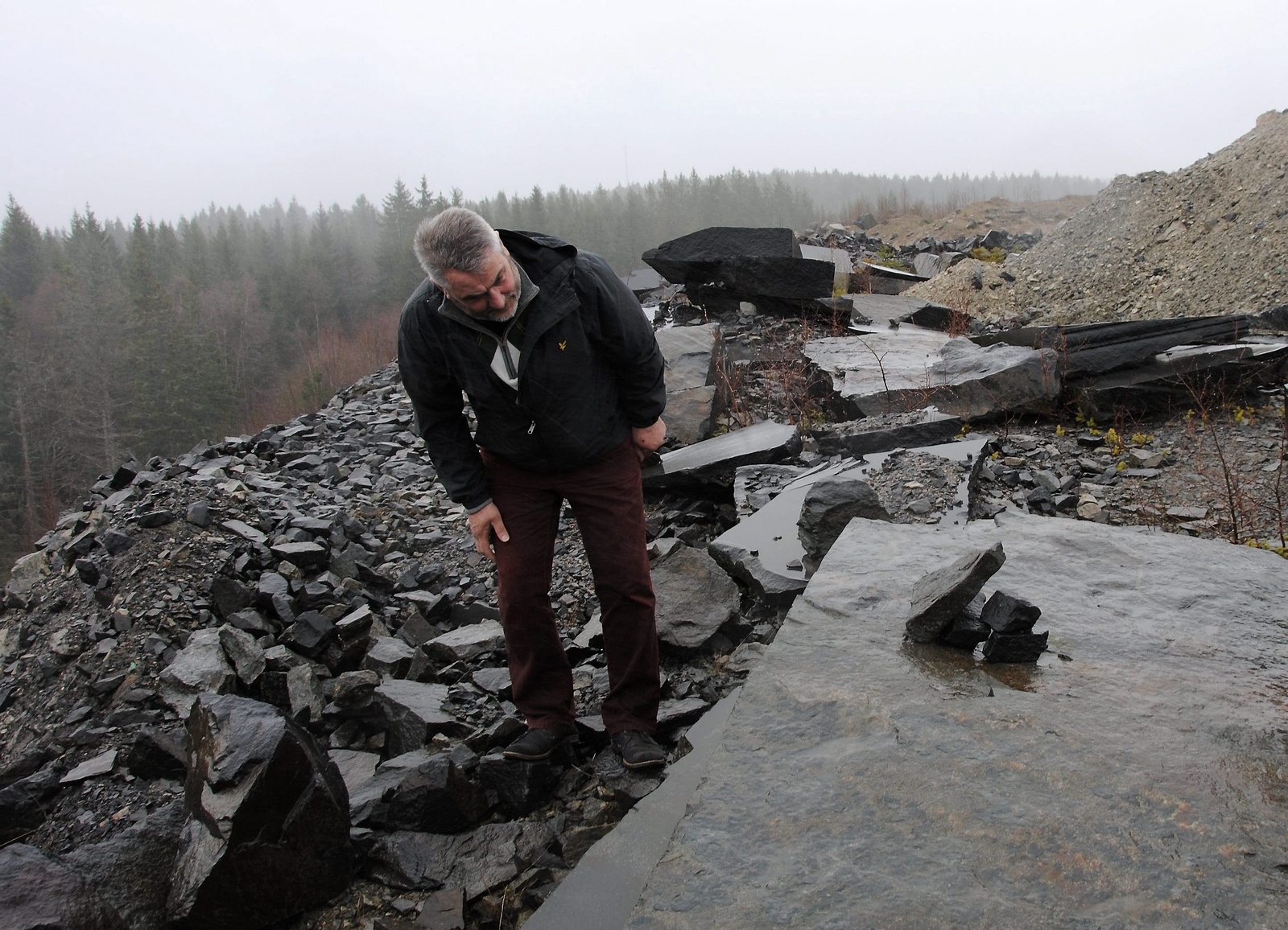 Tommy Johansson inspekterar den obearbetade stenen i diabas som ska komma att ingå i ett minnesmärke äver gårdsbränningen i Örkened 1678. Foto: Andreas Örwall Lovén