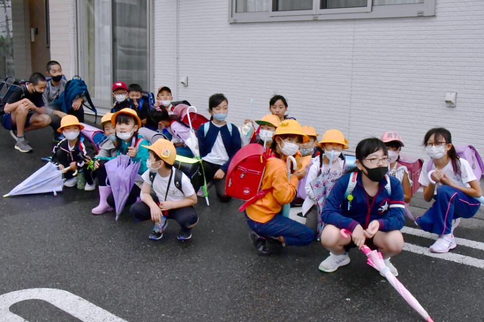 Barn på väg till skolan i Misawa i den japanska prefekturen Aomori tar skydd efter rapporterna om den nordkoreanska robotuppskjutningen.
