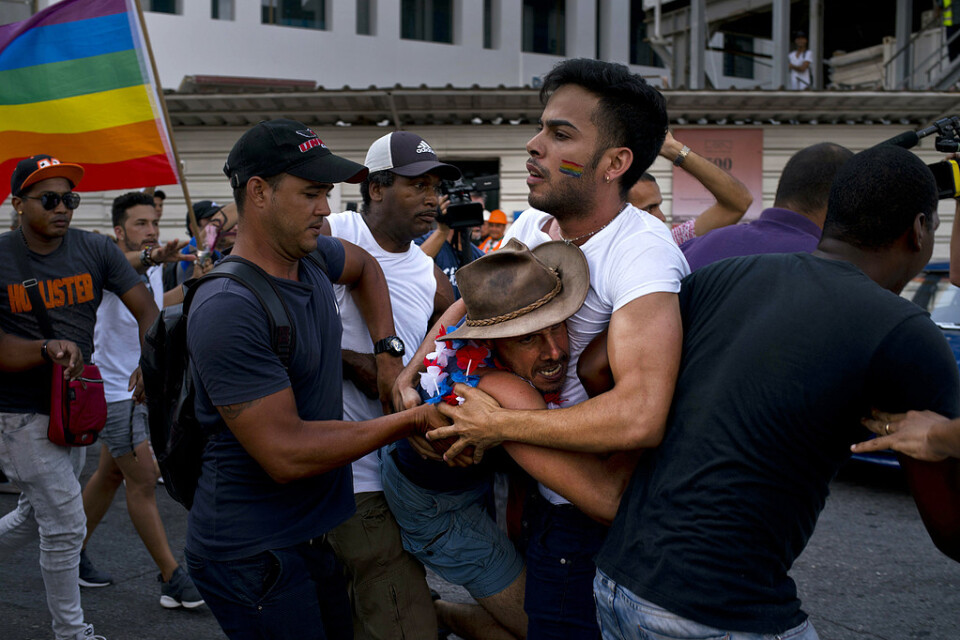 Civilklädd polis ingriper under en prideparad i Havanna, Kuba.