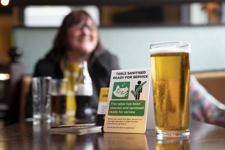 En kvinna tar en öl på en pub i Manchester, England, på måndagen.