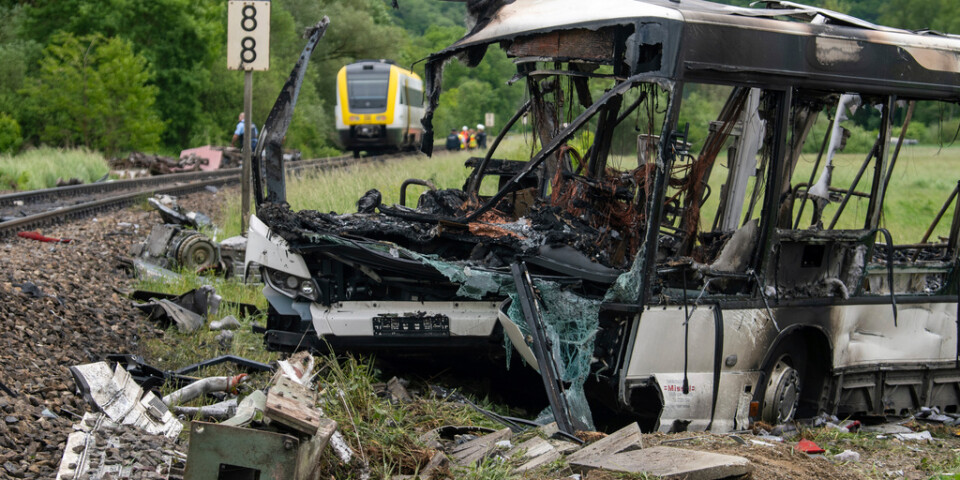 Den påkörda och utbrända bussen vid olycksplatsen i Blaustein i södra Tyskland.