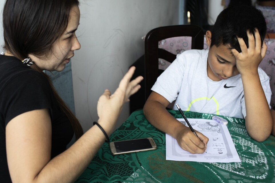 Maria Figueroa hjälper sin son Sebastian med hemläxan i Caracas, Venezuela, ett av många länder vars skolor hållits stängda. Bilden från i början av maj.