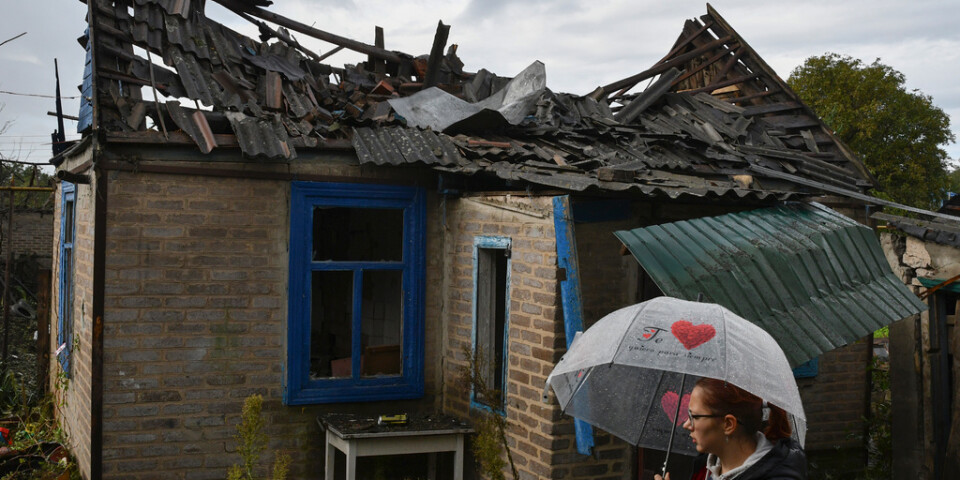 En kvinna utanför sitt hus som förstörts i en rysk attack mot staden Kramatorsk i början av oktober.