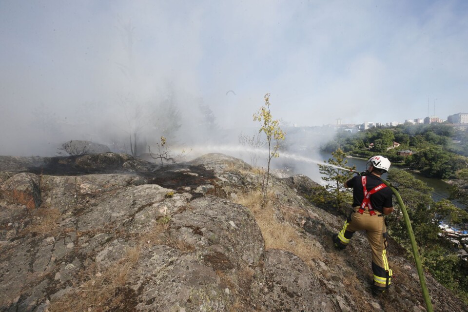 Brandpersonal bekämpar en skogsbrand i Nacka på onsdagen i somras. Att dessa hjältar som släckte sommarens skogsbränder nu ska förmånsbeskattas är oerhört beklagligt.