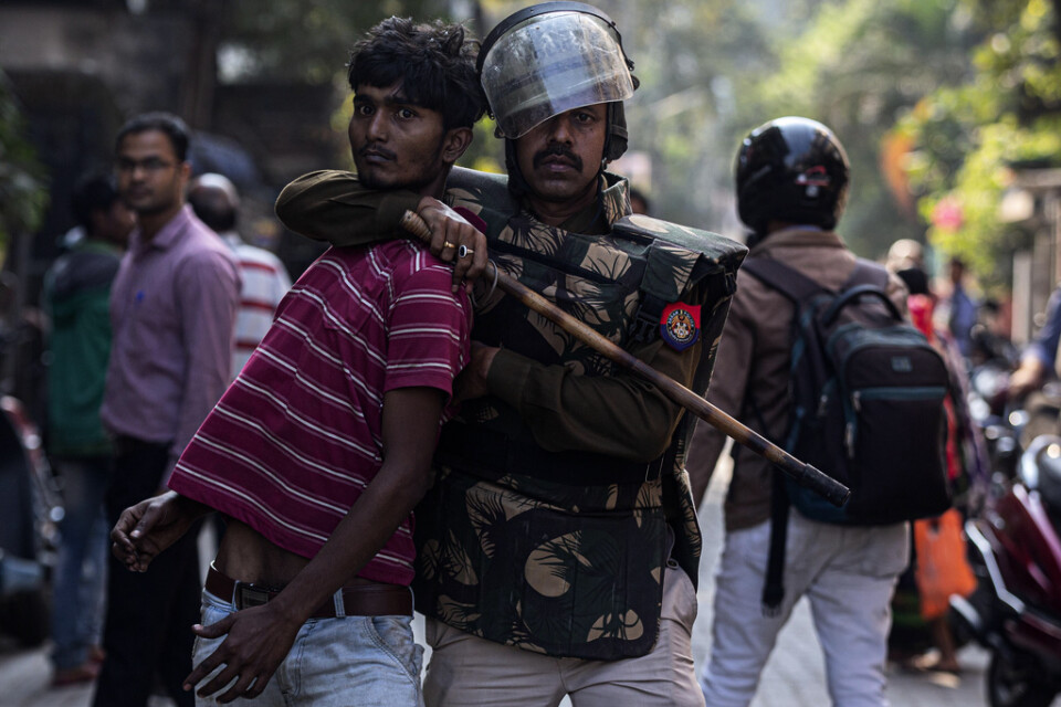 En polis håller fast en demonstrant vid protester i Gauhati på onsdagen. Protesterna riktas mot lagstiftning som kritiseras för att ytterligare marginalisera muslimer i Indien.