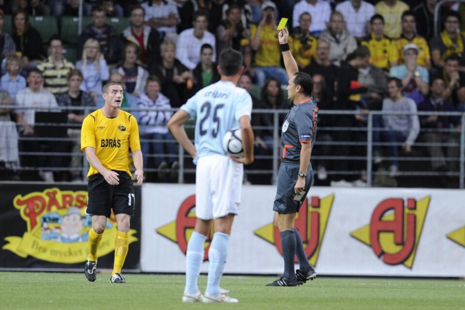 Elfsborgs James Keene fick gult kort av domaren Oleg Oriekhov medan Lazios Cribari såg på under matchen Elfsborg-Lazio på Borås Arena.