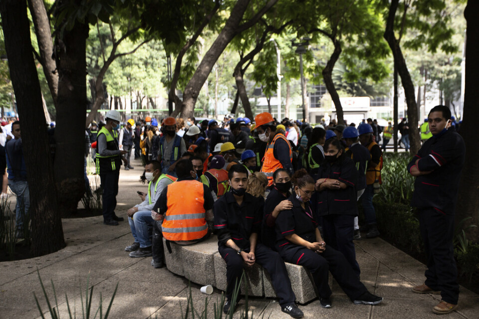 Anställda samlas utanför sin arbetsplats i Mexico City efter ett kraftigt jordskalv på tisdagen.