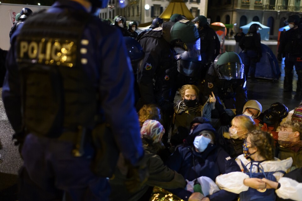 Polis för bort deltagare i klimatprotesten i närheten av den schweiziska parlamentsbyggnaden i Bern.