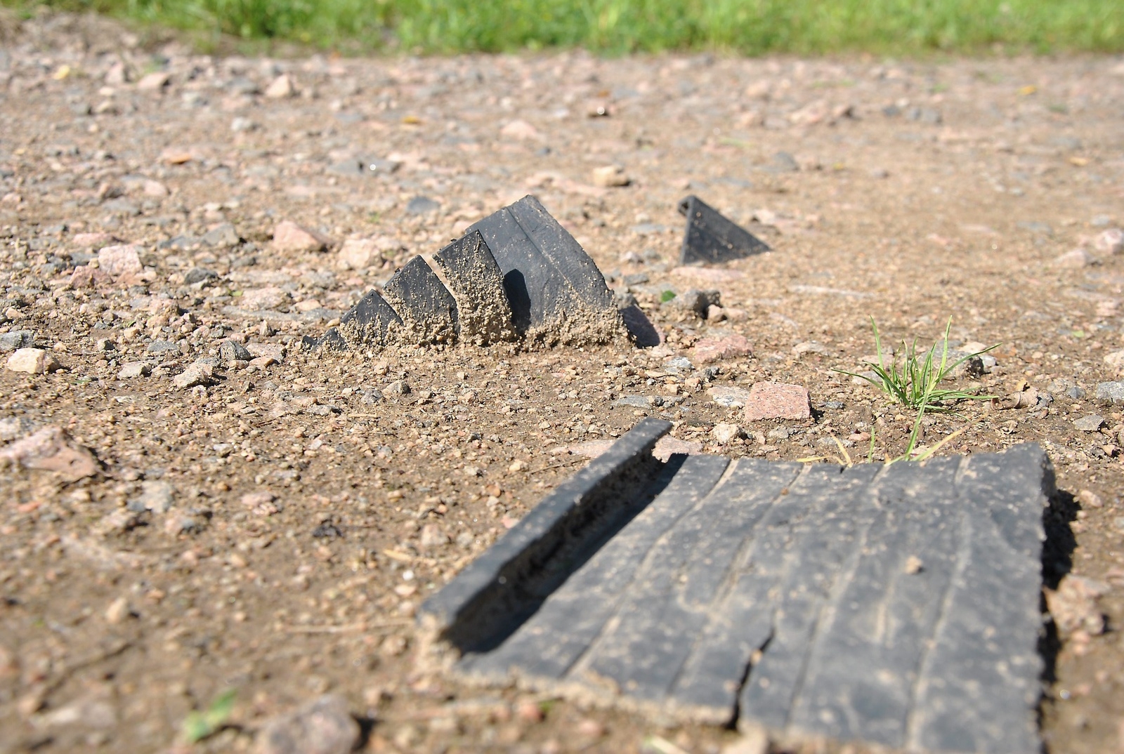 De förorenade massorna innehåller gummimellanlägg från järnvägen, som nu syns ligga slängda över området bakom reningsverket, här på grusvägen.Foto: Kristina Höjendal