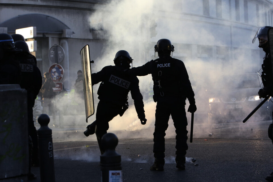 Kravallpolis i Marseille i södra Frankrike sparkar iväg en av polisens tårgasgranater. Bilden är från sammandrabbningar i samband med en av Gula västarnas manifestationer i januari i fjol.