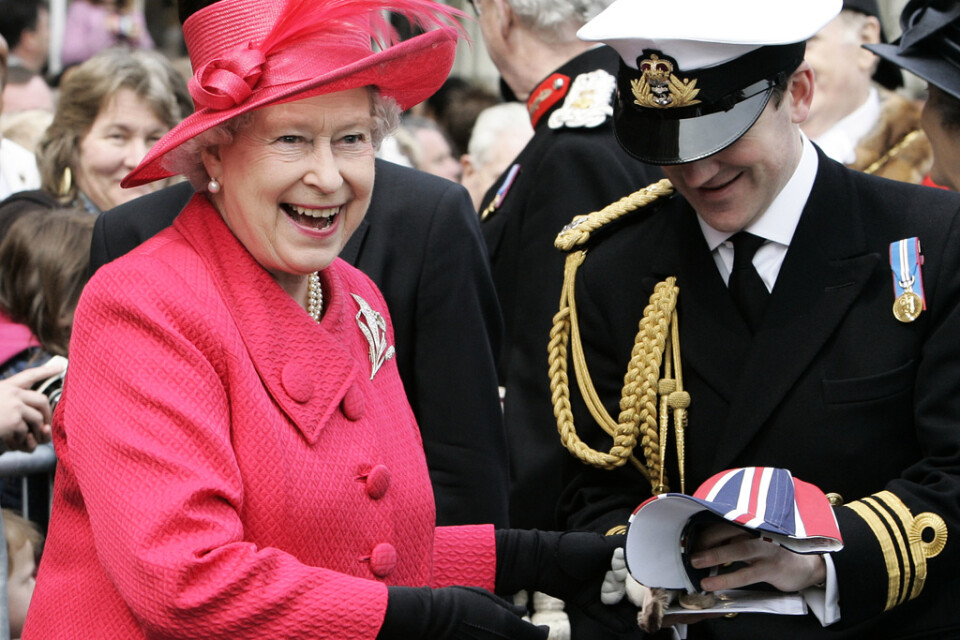 Drottningen överlämnar några gåvor hon fått till en assistent, under en "walkabout" i samband med sin 80-årsdag, i Windsor 2006.