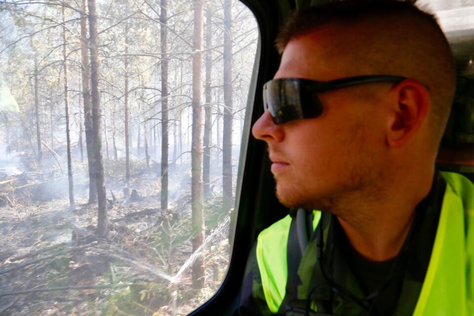 Erik Svensson, militär insatschef, bildar sig en uppfattning om skogsbranden inifrån bandvagnen.