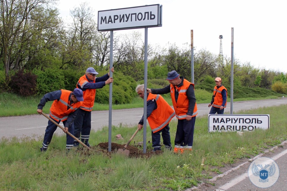 Ukrainska vägskyltar byts mot ryska utanför Mariupol.