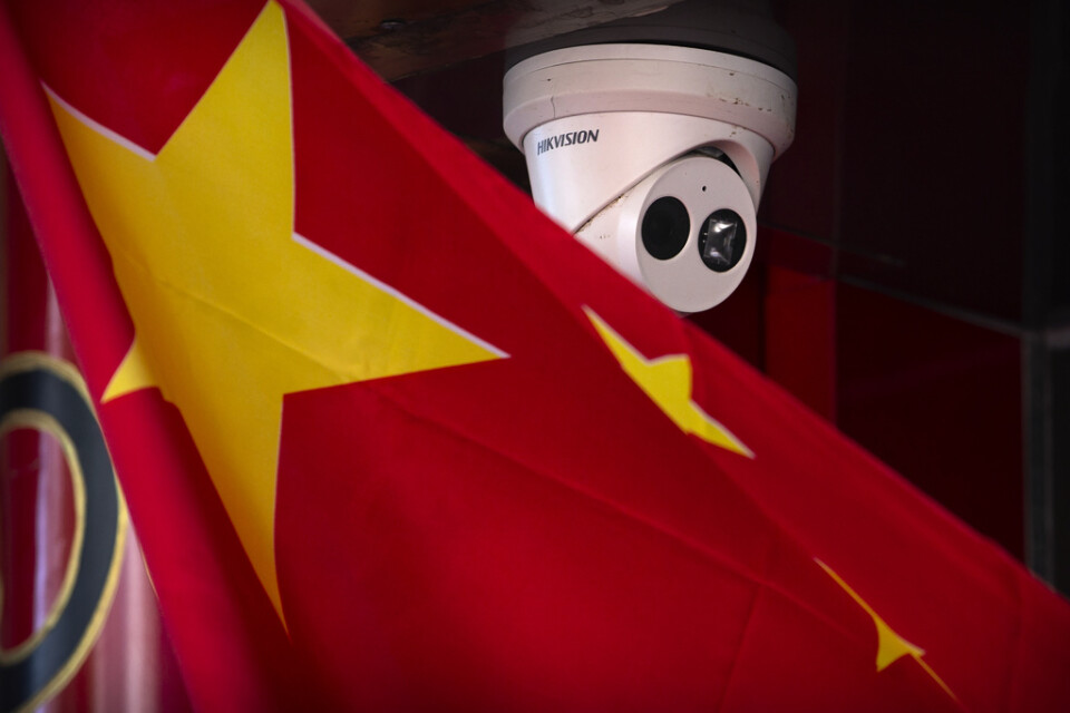 En övervakningskamera nära en kinesisk flagga vid en butik i Kinas huvudstad Peking.