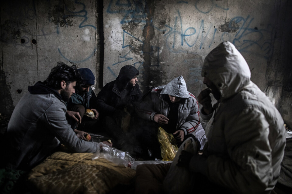 En grupp syrier äter frukost i en övergiven byggnad utanför Bihac i Bosnien-Hercegovina. Många migranter och flyktingar söker sig genom Bosnien för att ta sig in i EU via Kroatien. Arkivbild.
