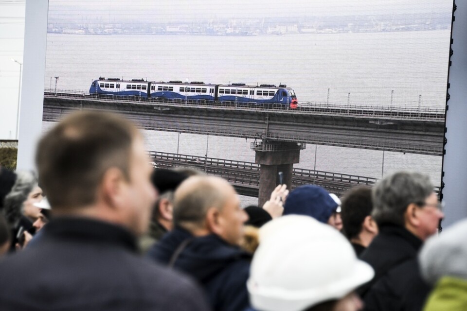 En storbildsskärm visar premiärresan över bron mellan Ryssland och Krimhalvön i december 2019. Vladimir Putin är ombord tåget, som enligt Dossier Center har samma betäckta antenner som presidentens eget bepansrade tåg.