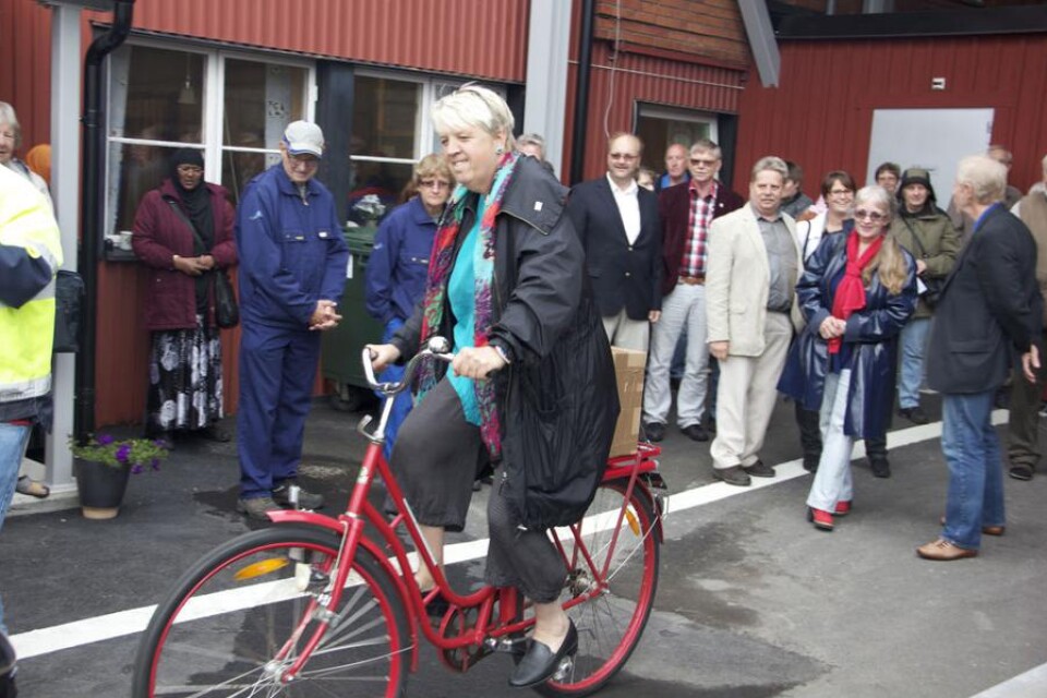 Kommunalrådet Ann-Marie Fagerström tog den röda cykeln och körde runt till de olika containrarna med avfall  när hon invigde den nya återvinningsstationen. Foto: Jan Andersson