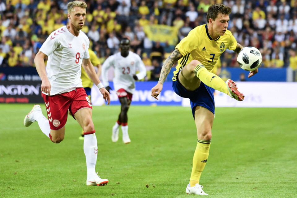 Sveriges Victor Nilsson Lindelöf följs av Dansken Nicolai Jørgensen under landskampen 2018.